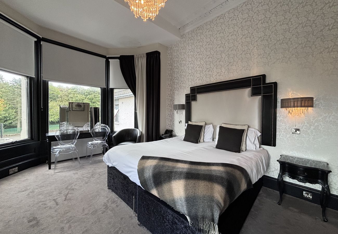 Richmond Park Hotel Junior Suite featuring a queen bed with stunning views of Richmond Park and the River Forth.